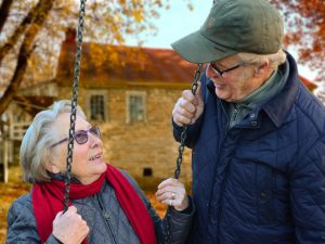 assisted living, elderly woman swinging and talking to elderly man